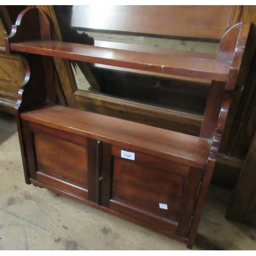 1426 - Early 20th Century mahogany wall bracket with two shelves and two panelled doors, a gilt triple dres... 