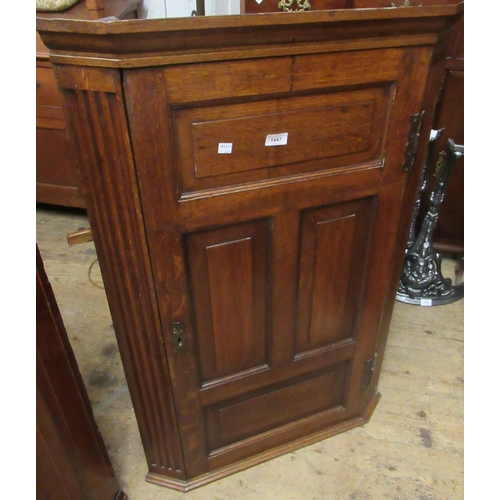 1447 - George III oak hanging corner cabinet, the moulded cornice above a fielded panel door flanked by ree... 