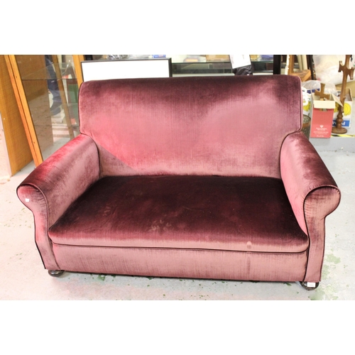 1491 - Early 20th Century purple velvet upholstered two seat sofa on bun front supports