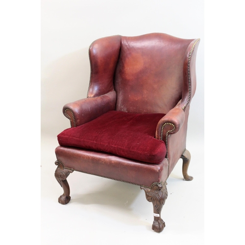 1544 - Tan leather upholstered wingback armchair in 18th century, raised on carved cabriole, claw and ball ... 