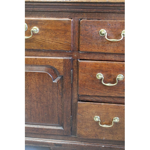 1605 - 18th Century oak dresser base, a moulded plank top above an arrangement of seven drawers with brass ... 