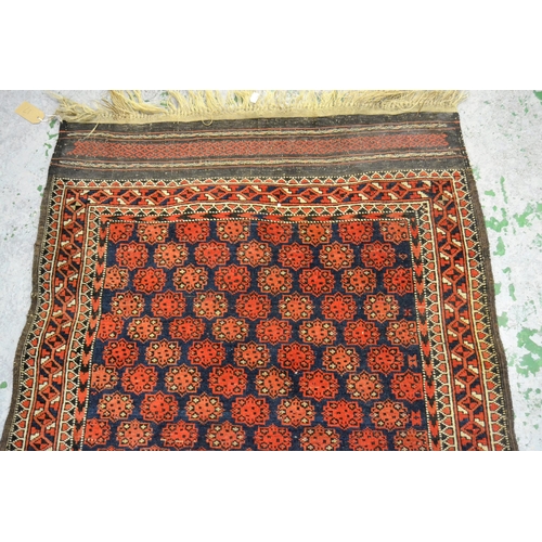 17 - Belouch rug with all-over medallion design with multiple borders on a midnight blue and red ground, ... 