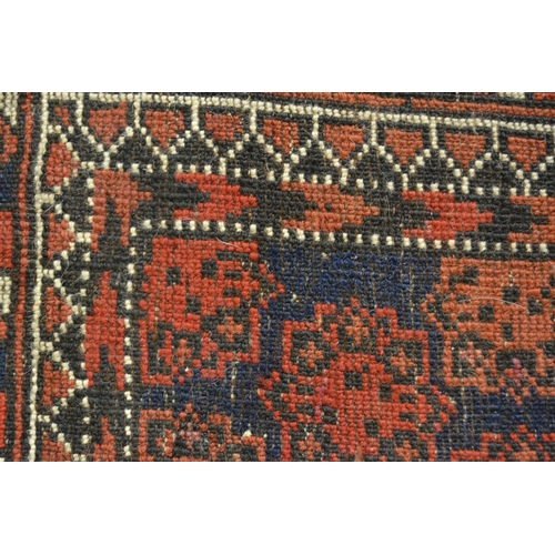 17 - Belouch rug with all-over medallion design with multiple borders on a midnight blue and red ground, ... 