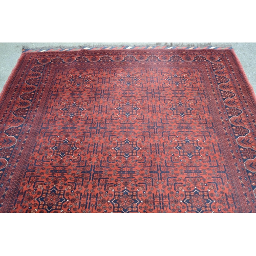 18 - Modern Afghan Belouch carpet with three rows of six gols on wine ground with borders, 300cms x 208cm... 