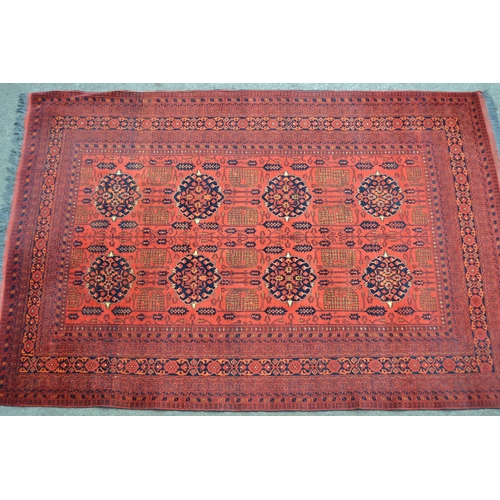 20 - Modern Afghan Belouch carpet with two rows of four gols and an all-over stylised floral design on a ... 