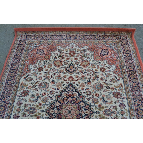 25 - Machine woven rug of Persian design in shades of cream and pink, 231cms x 169cms