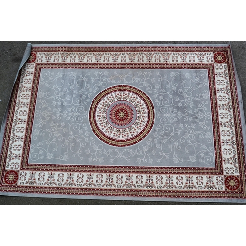 26 - Modern machine woven rug with a circular medallion on a grey ground with borders, 286cms x 198cms