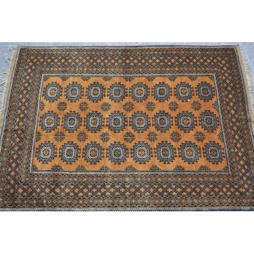 27 - Afghan gold ground carpet with three rows of eight gols within a multiple border, 290cms x 210cms