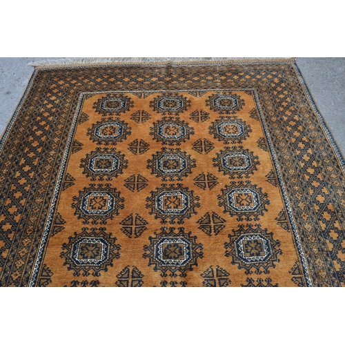 27 - Afghan gold ground carpet with three rows of eight gols within a multiple border, 290cms x 210cms