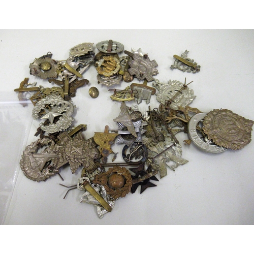 285 - Bag containing a large collection of various military cap badges etc.