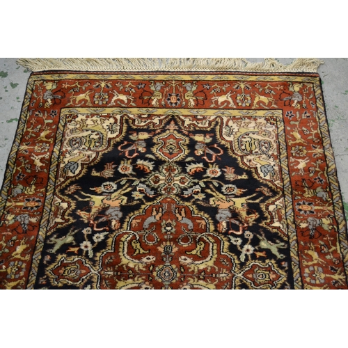 31 - Small Indo Persian rug with a medallion and hunting design on a blue ground with rust ground borders... 