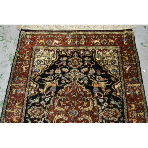 31 - Small Indo Persian rug with a medallion and hunting design on a blue ground with rust ground borders... 