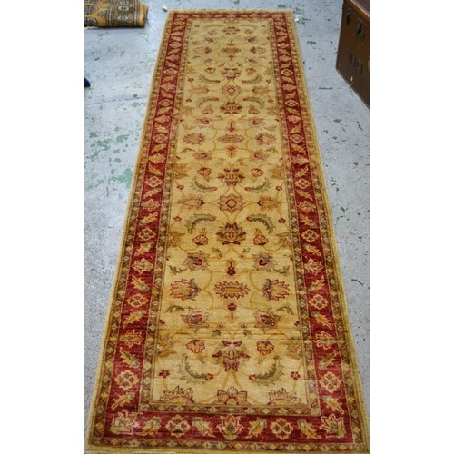 33 - Indo Persian runner with stylised floral design on an ivory ground with red ground borders, 290cms x... 