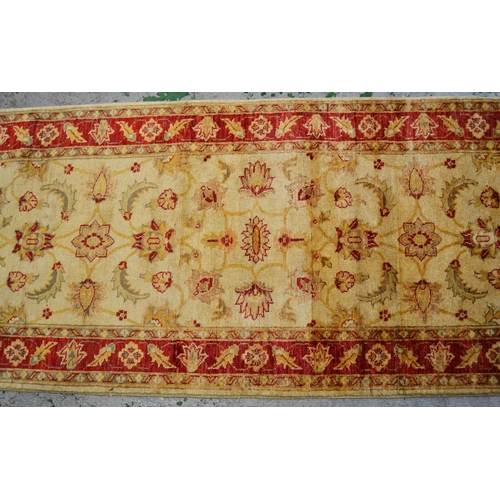 33 - Indo Persian runner with stylised floral design on an ivory ground with red ground borders, 290cms x... 