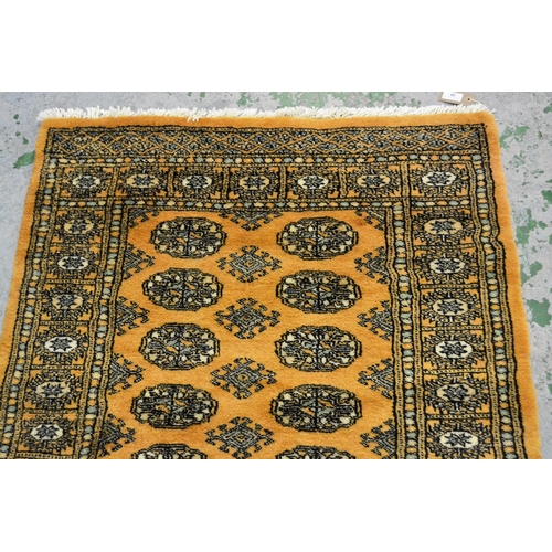 38 - Pakistan rug of Turkoman design with two rows of gols on a beige ground with borders, 153cms x 94cms