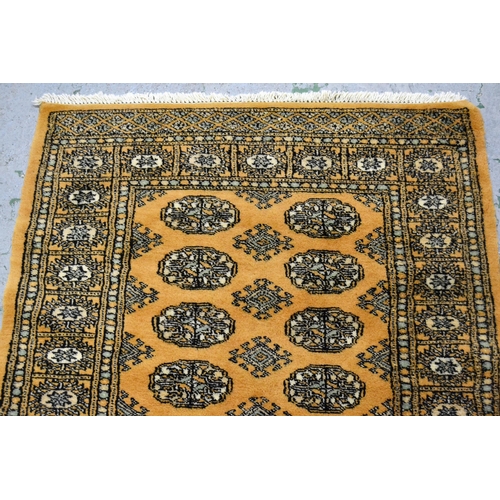 38 - Pakistan rug of Turkoman design with two rows of gols on a beige ground with borders, 153cms x 94cms