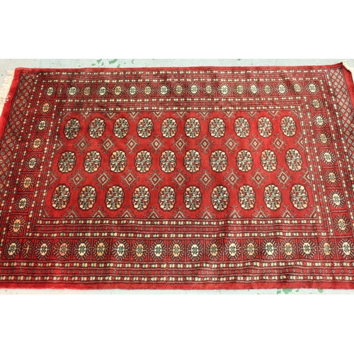 4 - Pakistan Bokhara rug with three rows of gols on a red ground, 189cms x 125cms, together with a simil... 