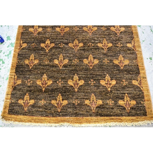 41 - Small Afghan rug with an all-over fleur de lis design in shades of tan, 174cms x 106cms