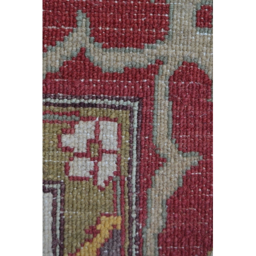 48 - Afghan carpet of Ziegler design with an all-over palmette pattern on an ivory ground with red ground... 