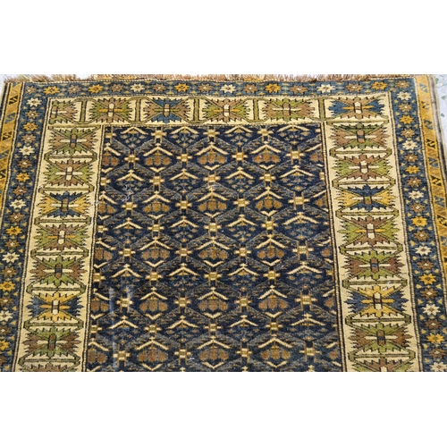 55 - Small Shirvan rug, the center panel with an all-over stylised floral design on blue ground, an ivory... 