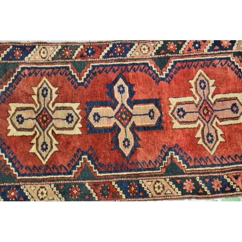 60 - Small Turkish rug with triple medallion design on a red ground with borders, 66cms x 136cms, togethe... 