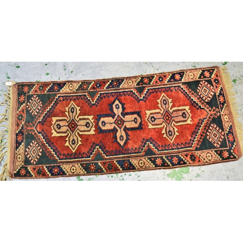 60 - Small Turkish rug with triple medallion design on a red ground with borders, 66cms x 136cms, togethe... 