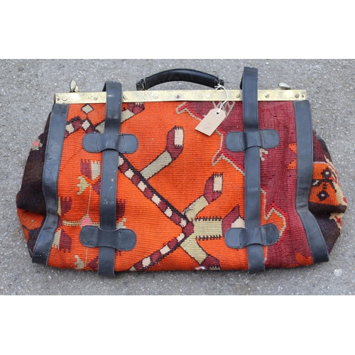13 - Modern Kelim carpet bag with leather and brass fittings, 50cms wide, together with a small Kelim mat