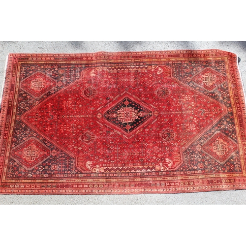16 - Qashqai rug with medallion and all-over design on red ground with corner designs and borders, (some ... 