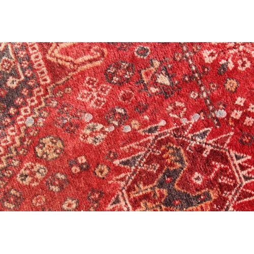 16 - Qashqai rug with medallion and all-over design on red ground with corner designs and borders, (some ... 