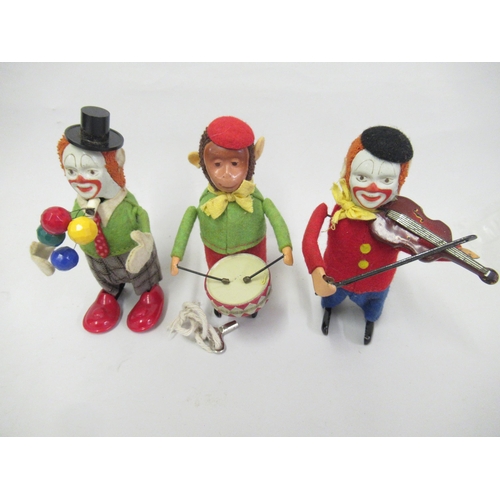 307 - Group of three German Schuco tin plate clockwork toys in the form of two clowns and a monkey drummer... 