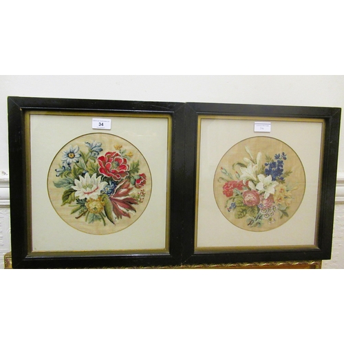 34 - Pair of circular mounted embroidered floral still life pictures, 22cms diameter, housed in ebonised ... 