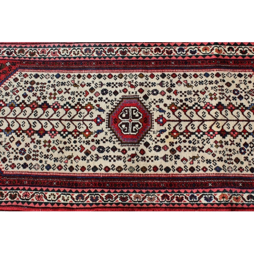 6 - Small 20th Century Belouch style rug with a medallion and all-over design on an ivory ground with bo... 
