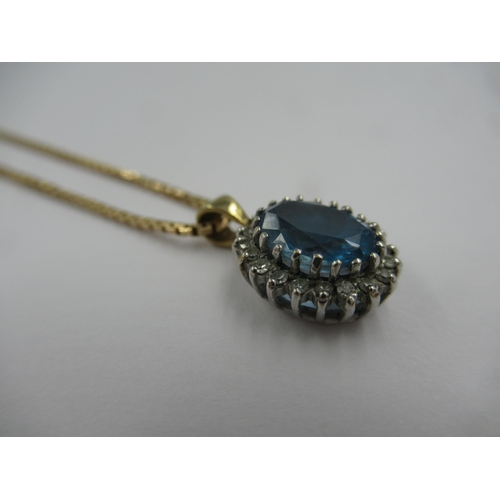 707 - Oval blue zircon and diamond cluster pendant suspended from a 9ct gold chain