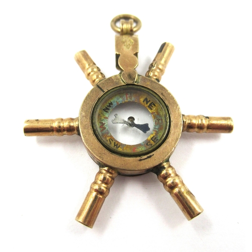 744 - 10ct Yellow gold novelty pocketwatch key in the form of a ships wheel with central compass, mounted ... 