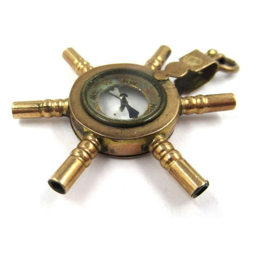 744 - 10ct Yellow gold novelty pocketwatch key in the form of a ships wheel with central compass, mounted ... 