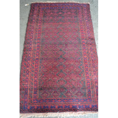 10 - Belouch rug with an all-over stylised design on a dark ground with multiple border, 173cms x 103cms