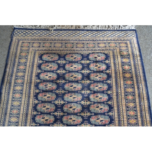 12 - Pakistan rug of Turkoman design with three rows of gols on a blue ground with borders (various damag... 