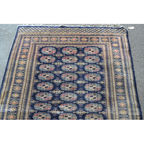 12 - Pakistan rug of Turkoman design with three rows of gols on a blue ground with borders (various damag... 