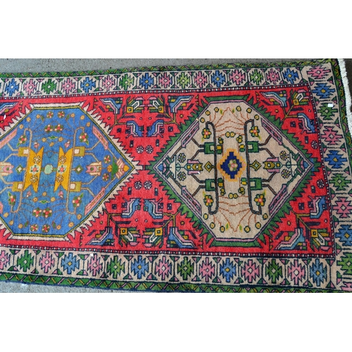 15A - Kurdish runner with a triple medallion design on a rose ground with borders, 266cms x 99cms