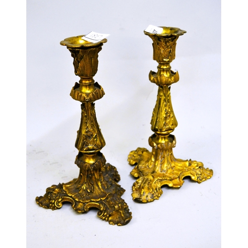 1807 - Pair of 19th Century French ormolu candlesticks on relief moulded triform bases, 25cms high