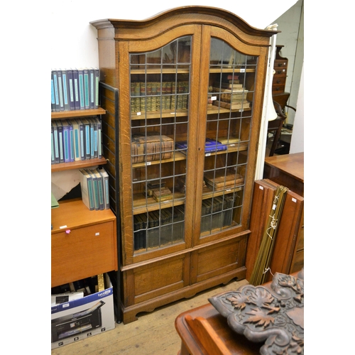 1822 - Mid 20th Century oak two door bookcase with leaded glazed doors (one at fault) and two panel doors b... 