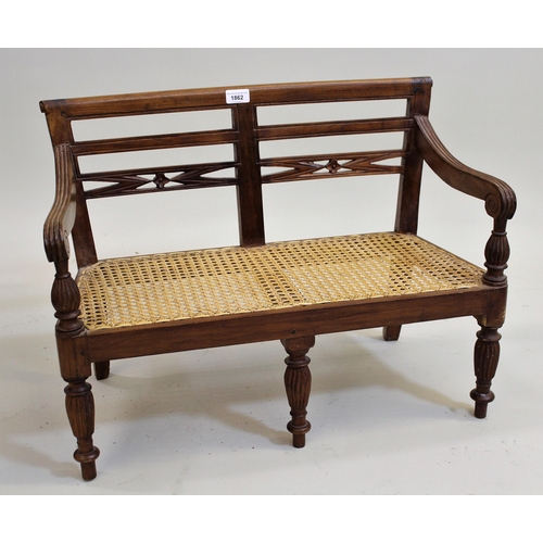 1862 - Reproduction Regency style child's sofa, with a carved splat back, cane seat and turned fluted front... 