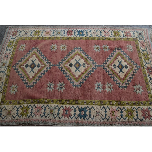 25 - Modern Turkish rug with a triple medallion design on a rose ground with borders, 180cms x 120cms