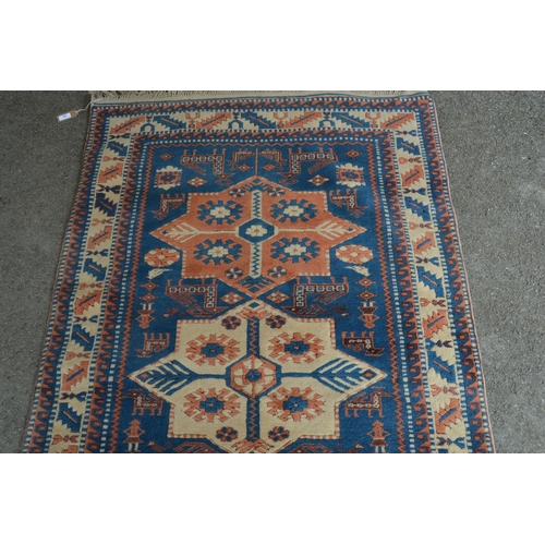 26 - Modern Turkish rug of Caucasian design with a triple medallion on a blue ground with borders, 180cms... 