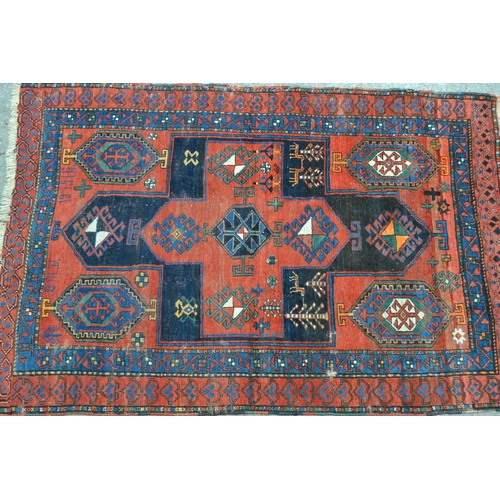 3 - Kurdish rug with a large centre medallion and subsidiary hooked medallion motifs in shades of chiefl... 