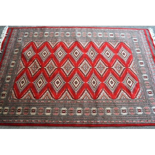 30 - Pakistan rug of Turkoman design with three rows of gols on a red ground with borders, 192cms x 128cm... 