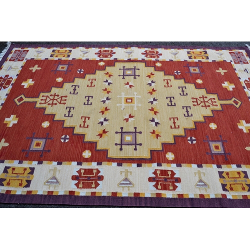 4 - Modern Kelim carpet of geometric design on brick red ground, approximately 9ft x 6ft