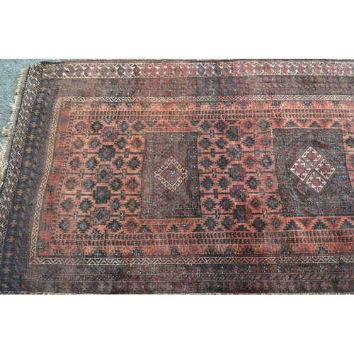 5 - Afghan Belouch rug with a triple medallion and all-over stylised design on a rust ground with multip... 