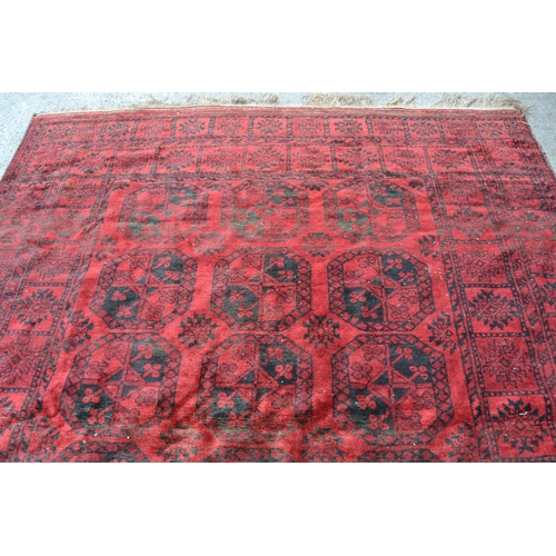 6 - Afghan carpet with three rows of six gols on a wine red ground with borders, (some damages and wear)... 