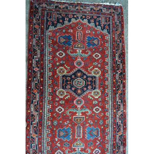 8 - Hamadan runner with a repeating medallion and all-over stylised floral design on a red ground with b... 